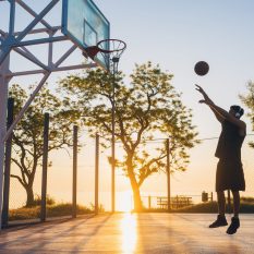 black man doing sports, playing basketball on sunrise, active lifestyle, sunny summer morning